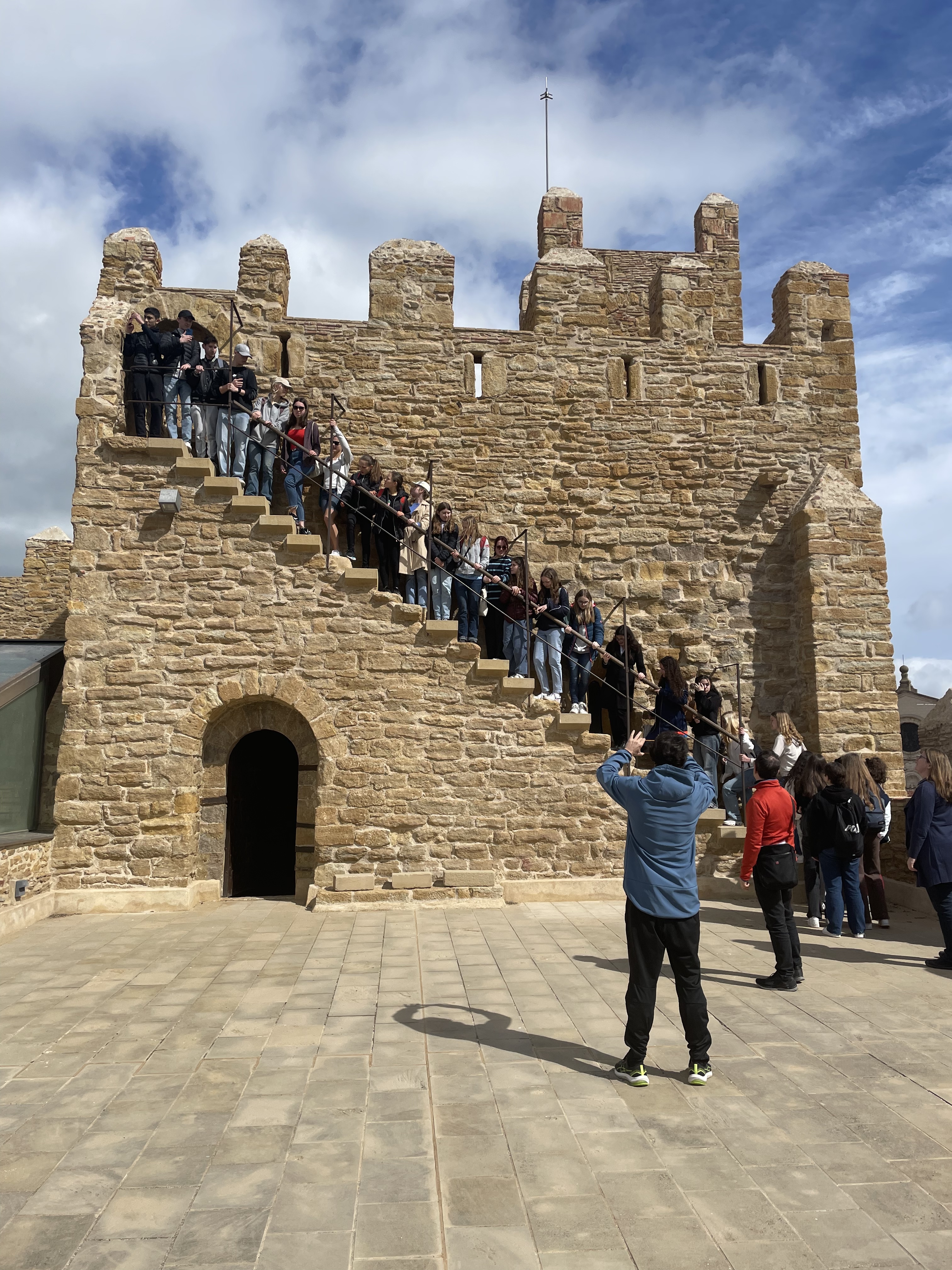 Visita guiada al castell amb l'alumnat d'alemanya posant-se a les escales de la doble torre del castell